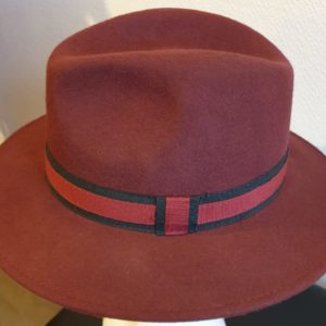 6 Chapeau grand bord en laine d'une couleur rouille originale s'inspirant à la fois du cyan, du magenta, du jaune et du noir. Ceinture bicolore.