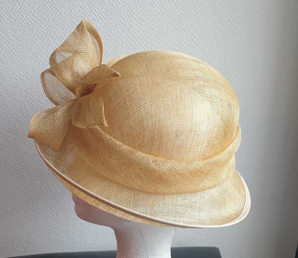 Chapeau de cérémonie de couleur neutre 100% SINAMAY. Les réglages de ce couvre-chef se réalisent soigneusement à l'intérieur par cordon de serrage.