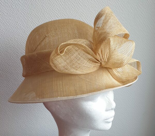 Chapeau de cérémonie de couleur neutre 100% SINAMAY. Les réglages de ce couvre-chef se réalisent soigneusement à l'intérieur par cordon de serrage.