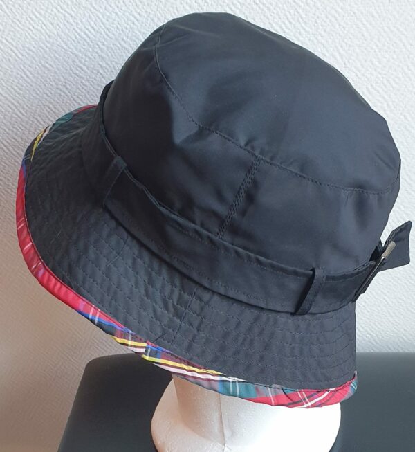 Bob unisexe de couleur noire imperméable et entièrement doublé en tissu polyester. Réglable à l'arrière par boucle de serrage. Finition biais écossais.