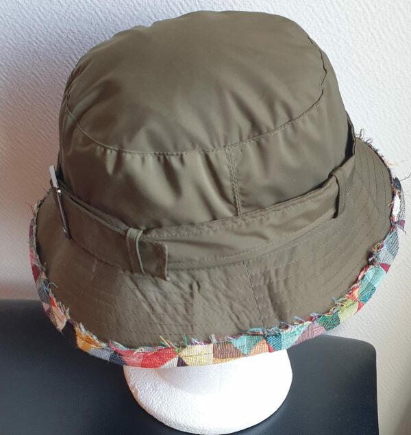 Bob unisexe de couleur verte imperméable et entièrement doublé en tissu polyester. Réglable à l'arrière par boucle de serrage. Finition biais en coton.