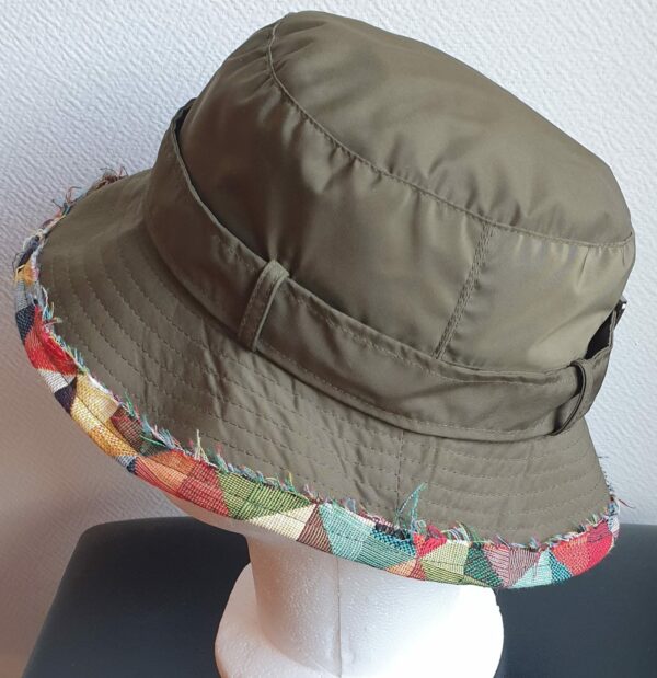 Bob unisexe de couleur verte imperméable et entièrement doublé en tissu polyester. Réglable à l'arrière par boucle de serrage. Finition biais en coton.
