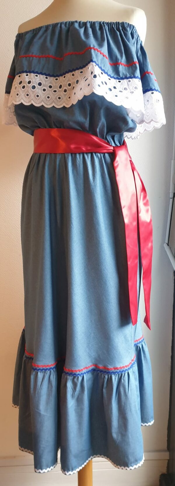 Robe carabela haïtienne bleue clair sur tenue traditionnelle. 2ceintures fournies. Elastique à la taille.