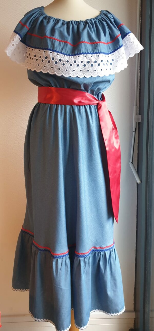 Robe carabela haïtienne bleue clair sur tenue traditionnelle. 2ceintures fournies. Elastique à la taille.