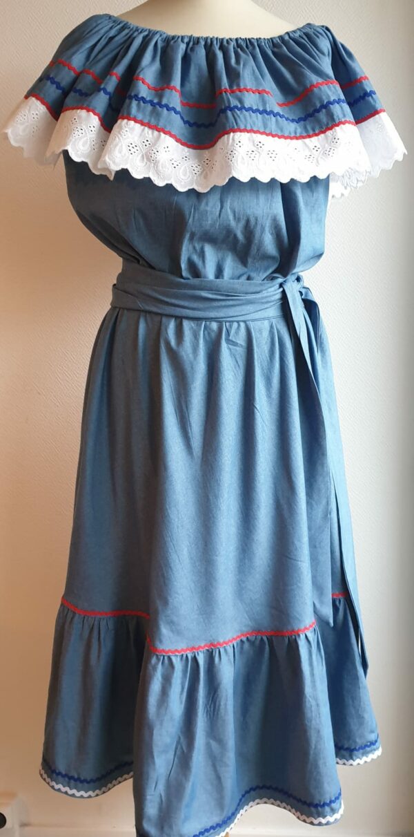 Robe carabela haïtienne bleue clair sur tenue traditionnelle. 2ceintures fournies. Elastique à la taille.