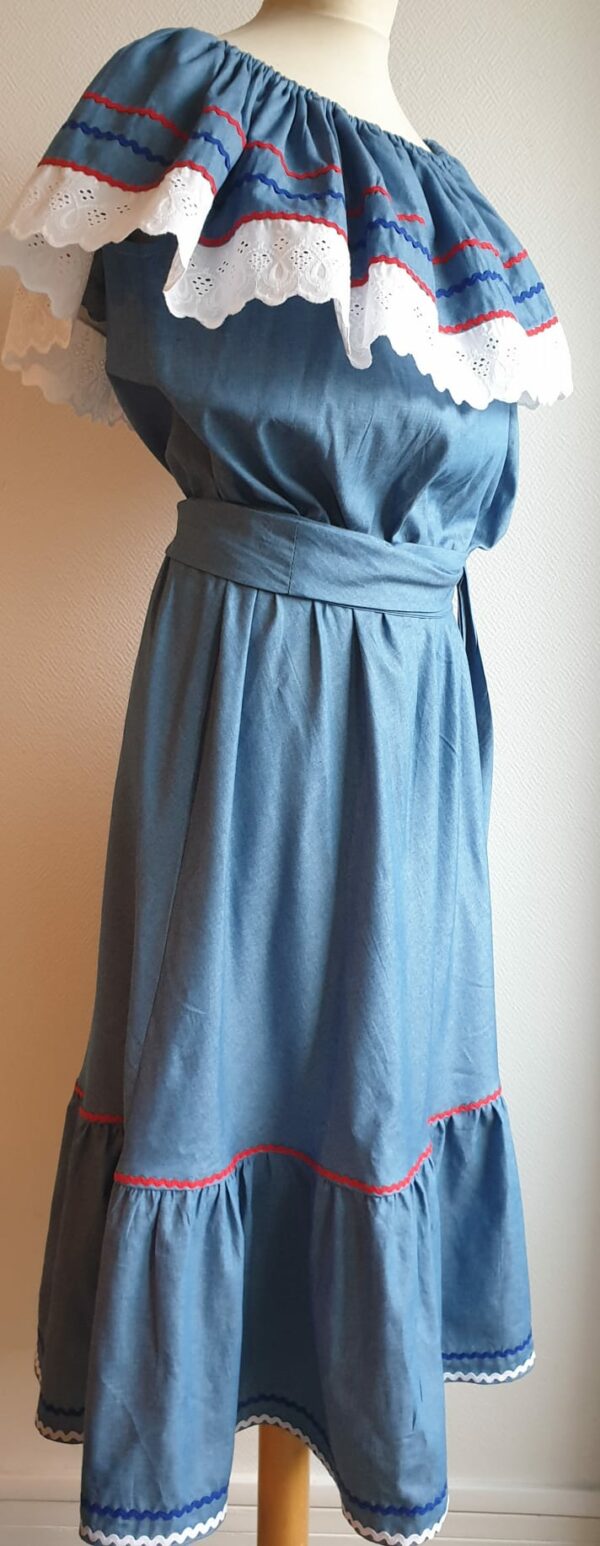 Robe carabela haïtienne bleue clair sur tenue traditionnelle. 2ceintures fournies. Elastique à la taille.