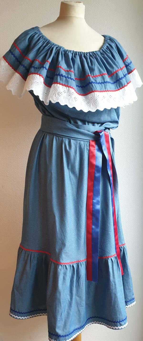 Robe carabela haïtienne bleue clair sur tenue traditionnelle. 2ceintures fournies. Elastique à la taille.