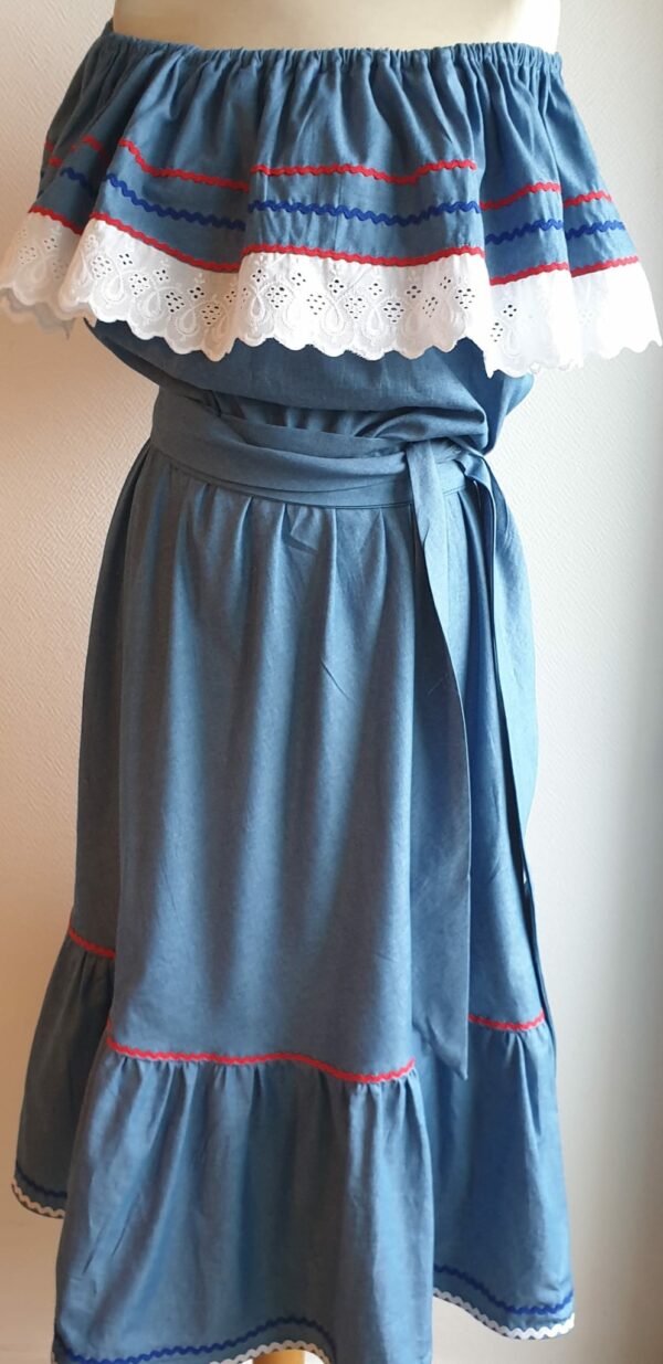 Robe carabela haïtienne bleue clair sur tenue traditionnelle. 2ceintures fournies. Elastique à la taille.