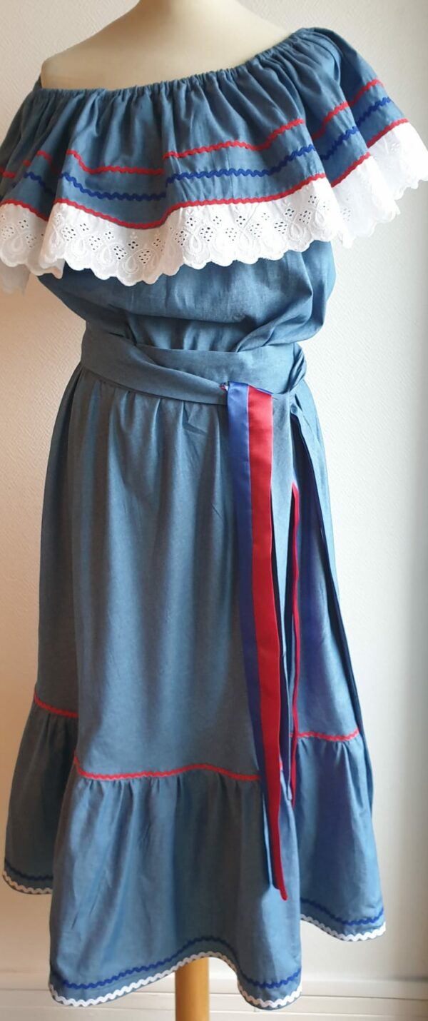 86.1Robe carabela haïtienne bleue clair sur tenue traditionnelle. 2ceintures fournies. Elastique à la taille. Taille : S,M,L,XL,XXL. Prix : 119.95€