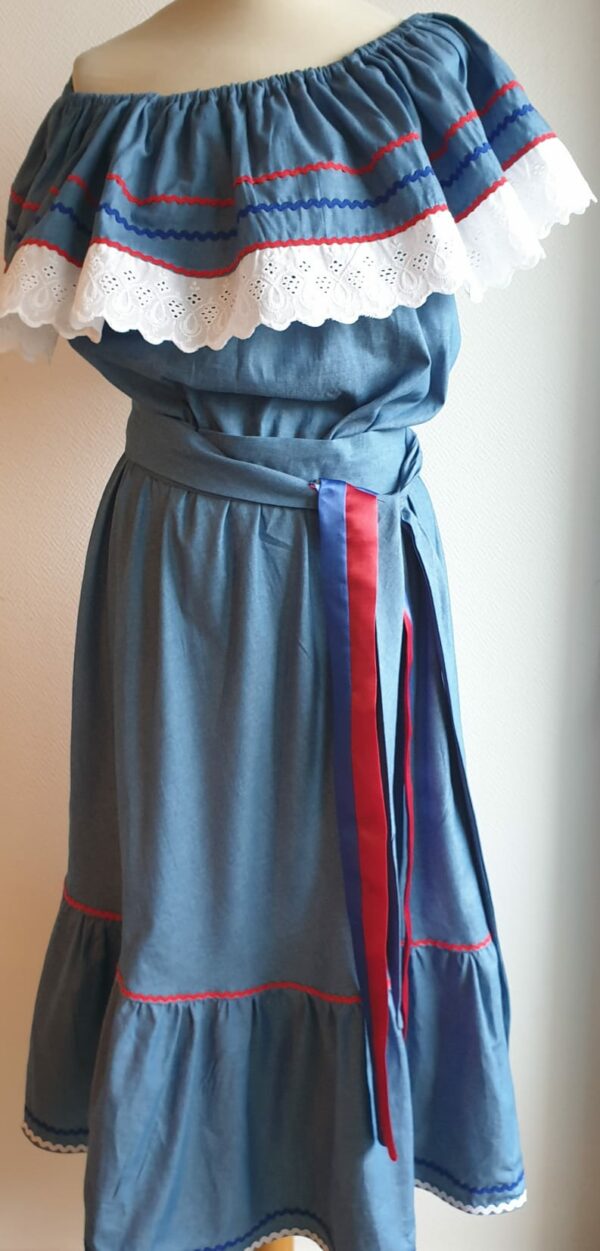 Robe carabela haïtienne bleue clair sur tenue traditionnelle. 2ceintures fournies. Elastique à la taille.