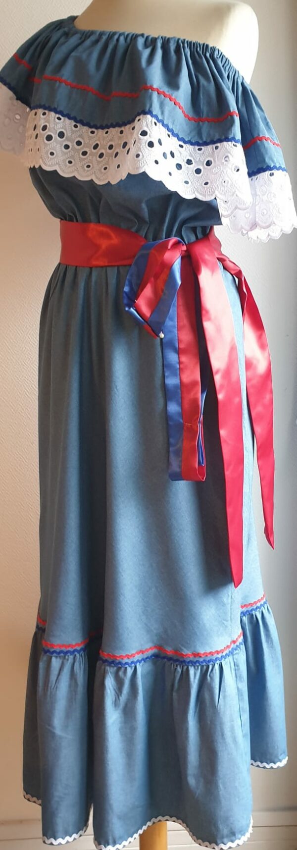 Robe carabela haïtienne bleue clair sur tenue traditionnelle. 2ceintures fournies. Elastique à la taille.