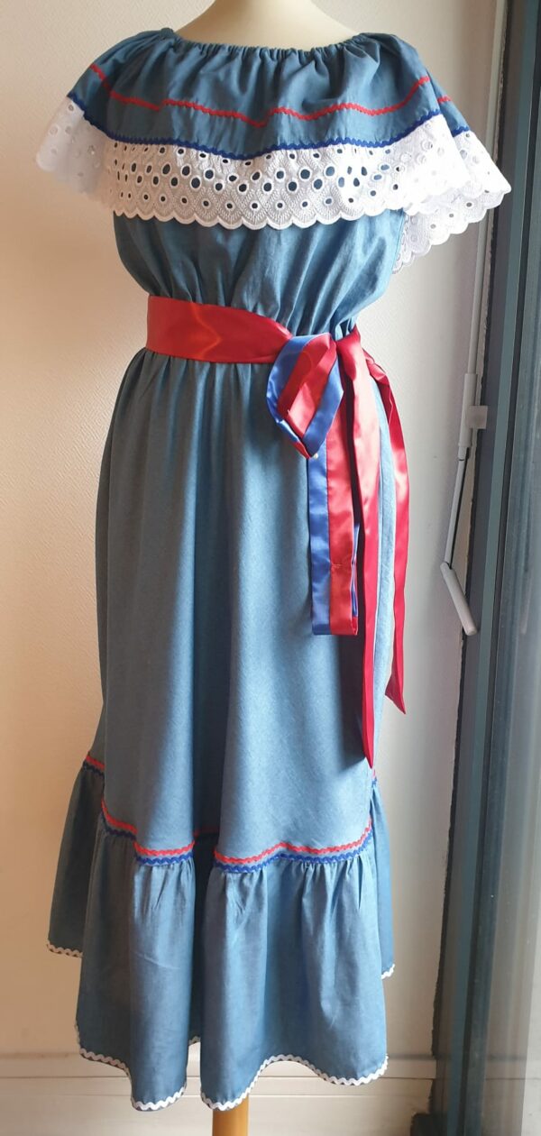 Robe carabela haïtienne bleue clair sur tenue traditionnelle. 2ceintures fournies. Elastique à la taille.