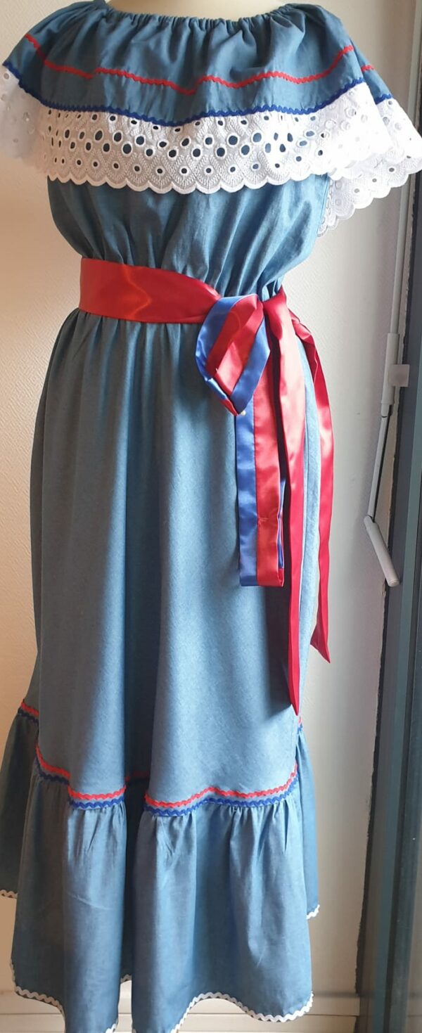 Robe carabela haïtienne bleue clair sur tenue traditionnelle. 2ceintures fournies. Elastique à la taille.