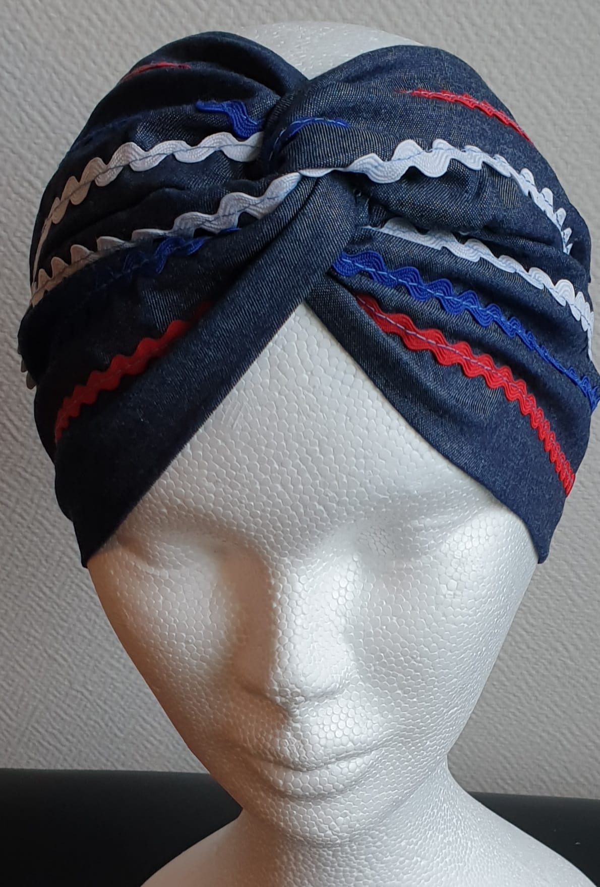 90.1Bandeau sur un tissu carabela de tradition haïtienne. Bleu marine assorti de guirlandes tricolores. Taille unique. Confectionné en France. Prix : 23€