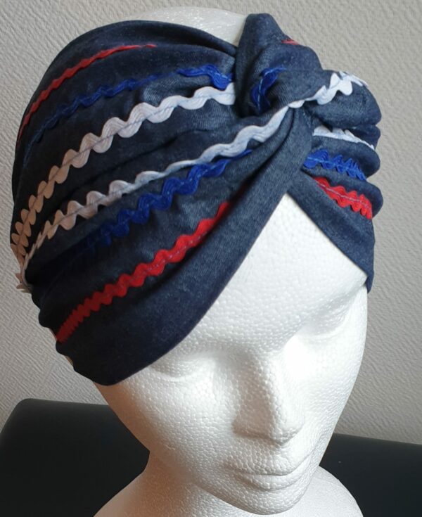 Bandeau sur un tissu carabela de tradition haïtienne. Bleu marine assorti de guirlandes tricolores.