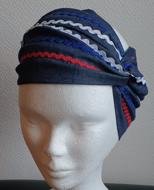 Bandeau sur un tissu carabela de tradition haïtienne. Bleu marine assorti de guirlandes tricolores.