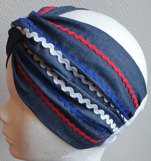 Bandeau sur un tissu carabela de tradition haïtienne. Bleu marine assorti de guirlandes tricolores.