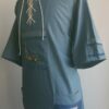 Chemise bleue carabela en tenue traditionnelle haïtienne brodée à la main. Deux poches latérales, une poche brodée centrale, une mini poche sur une manche courte.