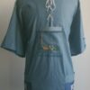 Chemise bleue carabela en tenue traditionnelle haïtienne brodée à la main. Deux poches latérales, une poche brodée centrale, une mini poche sur une manche courte.