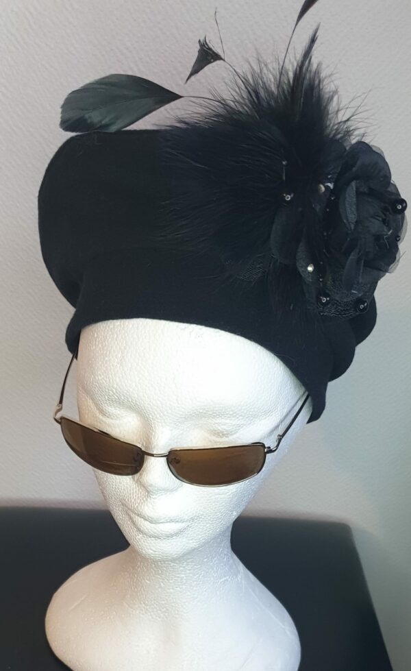 13.1Chapeau de cérémonie en laine style béret. Sa couleur est d'un bleu indigo très original. Un ornement floral soigneusement disposé sur le côté et sur la coiffe en grande fleur de décor. Possibilité de détachement. Taille unique. Création Anjero.