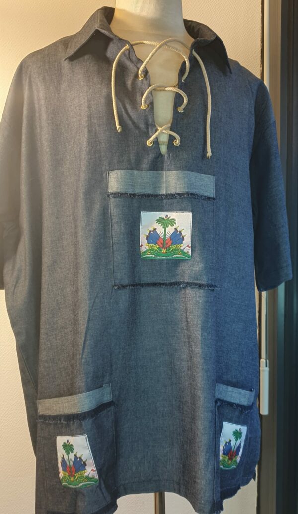 7.1Chemise Carabela homme d'après une tenue traditionnelle haïtienne en bleu marine. Un joli col est proposé avec sur le devant des œillets noués par un cordon blanc. Taille : M, L, XL, XL Prix : 79.95€.
