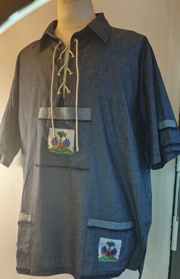 7.2Chemise Carabela homme d'après une tenue traditionnelle haïtienne en bleu marine. Un joli col est proposé avec sur le devant des œillets noués par un cordon blanc. Taille : M, L, XL, XL Prix : 79.95€.