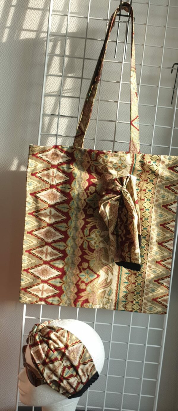 5.2Tote-bag en tissu Wax sur une décoration évoquant les régions climatiques tropicales, assorti d'un même bandeau. Dimension : 38 sur 41cm.