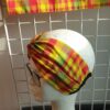 14.2Bandeau en tissu Wax et Madras aux couleurs orangées et verdoyantes sur une combinaison de deux pièces. Confectionné par Anjero Création.