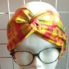 14.3Bandeau en tissu Wax et Madras aux couleurs orangées et verdoyantes sur une combinaison de deux pièces. Confectionné par Anjero Création.