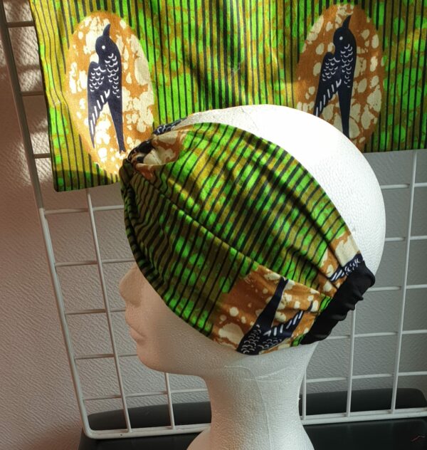 14.4Bandeau en tissu Wax et Madras aux couleurs orangées et verdoyantes sur une combinaison de deux pièces. Confectionné par Anjero Création.