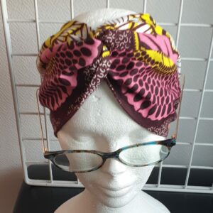 15.1Bandeau en tissu Wax sur une décoration évoquant des ombres alignées sur un fond tricolor. Dimension : 38cm sur 41cm. Prix : 26€. Confectionné par Anjero Création.