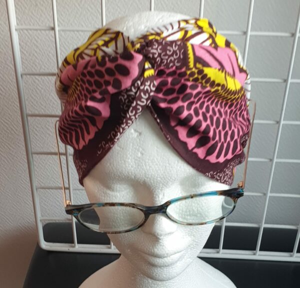 15.1Bandeau en tissu Wax sur une décoration évoquant des ombres alignées sur un fond tricolor. Dimension : 38cm sur 41cm. Prix : 26€. Confectionné par Anjero Création.