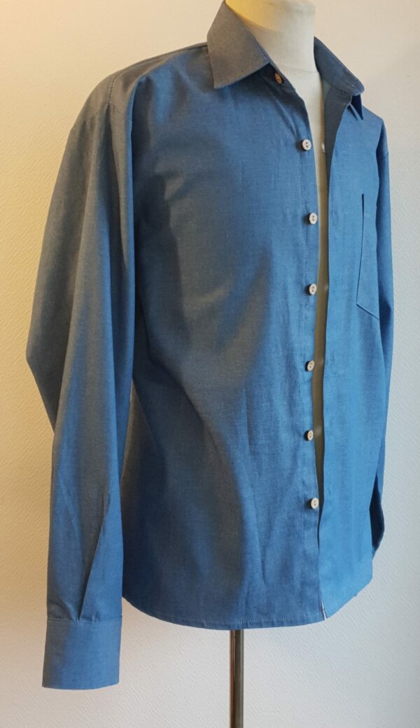 15.2Chemise homme en bleu. Tissu Chambray tout en coton. La coupe soigneusement ceintrée près du corps est accompagnée d'un col boutonné sur le devant. Les boutons sont en bois coco. Différentes tailles. La fabrication est française, imaginée et conçue à Paris par AnjéroCréation.
