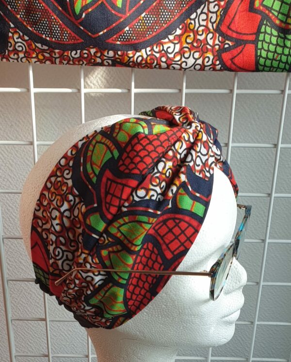 15.4Bandeau en tissu Wax sur une décoration évoquant des ombres alignées sur un fond tricolor. Dimension : 38cm sur 41cm. Confectionné par Anjero Création.