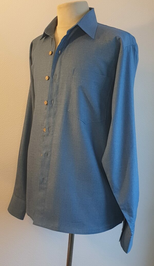 15.4Chemise homme en bleu. Tissu Chambray tout en coton. La coupe soigneusement ceintrée près du corps est accompagnée d'un col boutonné sur le devant. Les boutons sont en bois coco. Différentes tailles. La fabrication est française, imaginée et conçue à Paris par AnjéroCréation.