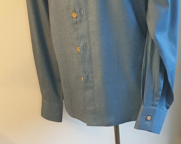 15.5Chemise homme en bleu. Tissu Chambray tout en coton. La coupe soigneusement ceintrée près du corps est accompagnée d'un col boutonné sur le devant. Les boutons sont en bois coco. Différentes tailles. La fabrication est française, imaginée et conçue à Paris par AnjéroCréation.