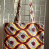 6.4Tote-bag en tissu Wax sur une décoration évoquant vagues et coquillages aux couleurs d'été assorti d'un même bandeau aux mêmes couleurs et décorations. Dimension : 38cm sur 41cm. Confectionné et créé par Anjero Création.