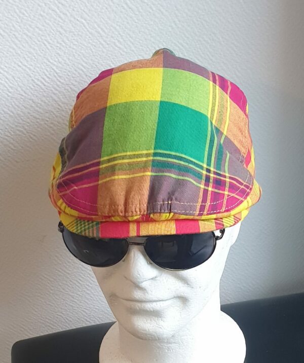 67.1Béret Madras cent pour cent coton aux couleurs vivifiantes sur un tissu consolidé entièrement doublé. La doublure a été soigneusement posée en satin pour un confort optimal. Taille unique mais réglable et extensible à l'arrière. Ce produit est une création artisanale modestement confectionné par Anjero. Prix : 27,50€.