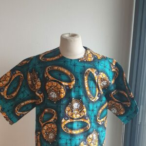 8.1Chemise en tissu coton wax assortie d'un imprimé bague or sur fond vert bleu océan. Ce modèle est conçu en manches courtes. Une fermeture éclaire à bout fermé subtilement dissimulée est ajoutée sur l'épaule gauche. Elle est faite de nylon souple et d'une tête de fermeture à glissière en métal, solide et durable. La dent de la fermeture à glissière est lisse et ne s'accroche pas, ajoutant ainsi, une touche attractive et supplémentaire à la confection. Taille unique. Ce produit est entièrement confectionné, en série limitée, par Anjero. Prix : 39,95€.