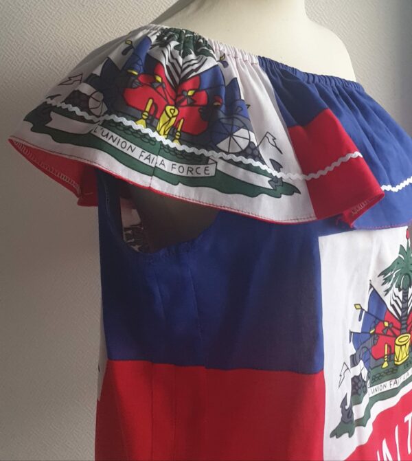 3.3Corsage bleu blanc rouge vert orné du drapeau haïtien avec un col bardot élastique. Zigzagblanc et bas de corsage. Un style très élégant et confortable à porter. Taille : S, M, L, XL. Entièrement confectionné aux ateliers AnjeroCréation.