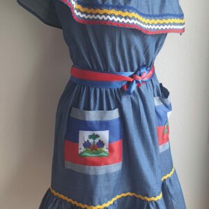 4.1Robe enfant carabela sur une tenue traditionnelle haïtienne. Ce vêtement est élastique à la taille. Il est présenté avec ses deux poches ornées du draapeau d'Haïti et sa ceinture bicolore en rouge et bleue. Taille : 6, 7 ans. Entièrement conçu et réalisé aux ateliers AnjeroCréation à Paris. Prix : 109.95€.