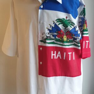 1.1Chemise coupe traditionnelle sur un décor haïtien ornée du drapeau dans un tissu 100 pour 100 coton. Les manches semi-longues apportent un style harmonieux à la confection,  entièrement conçue et réalisée aux ateliers AnjeroCréation à Paris. Taille : S, M, L, XL. Prix : 79,95€.