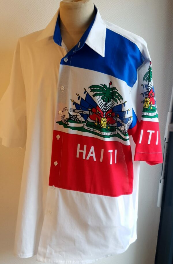 1.4Chemise coupe traditionnelle sur un décor haïtien ornée du drapeau dans un tissu 100 pour 100 coton. Les manches semi-longues apportent un style harmonieux à la confection,  entièrement conçue et réalisée aux ateliers AnjeroCréation à Paris. Taille : S, M, L, XL.