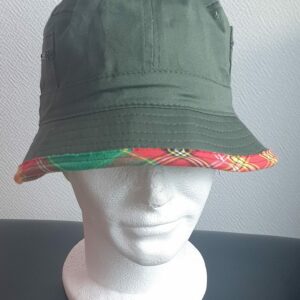 11.1Bob en vert kaki sur un tissu 100% coton. L'ajout de deux poches latérales zipées apporte une touche harmonieuse à ce couvre-chef. Les finitions en bordure sont en Madras et entièrement conçues puis réalisées aux ateliers AnjeroCréation à Paris.