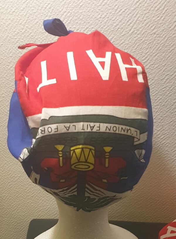 2.3Turban pleine tête orné du drapeau haïtien. Ce couvre-chef apparenté tout à fait original dispose d'une parfaite élasticité à l'arrière pour une adaptation idéale. Ce dernier est conçu et réalisé aux ateliers AnjeroCréation  à Paris.
