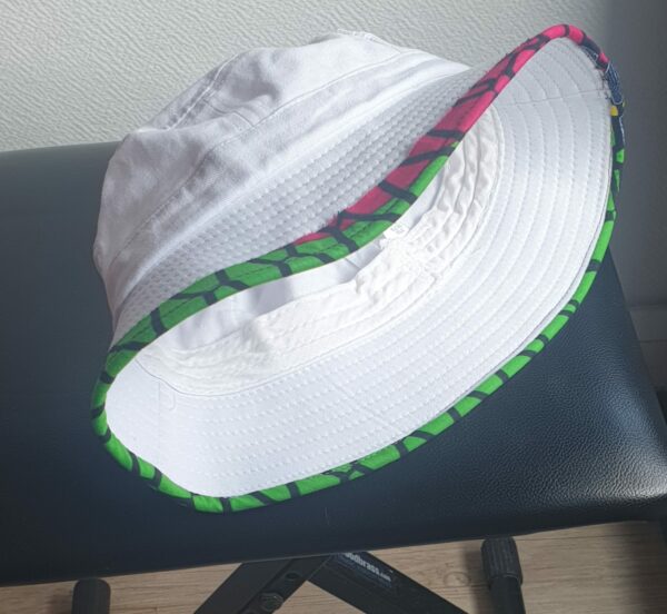 2.5Bob tout en blanc sur un tissu 100% coton. L'ajout de deux poches latérales zipées apporte une touche harmonieuse à la confection. Les finitions en bordure sur le pourtour de ce couvre-chef sont en WAX et réalisées aux ateliers AnjeroCréation à Paris.