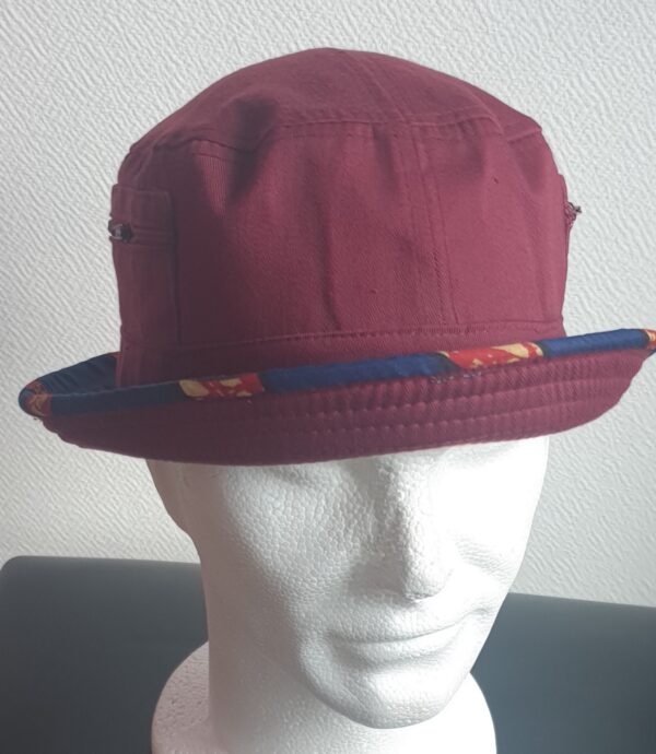 3.1Bob tout en rouge grenat sur un tissu 100% coton. L'ajout de deux poches latérales zipées apporte une touche harmonieuse à la confection. Les finitions en bordure sur le pourtour de ce couvre-chef sont en WAX et réalisées aux ateliers AnjeroCréation à Paris. Prix : 15.95€