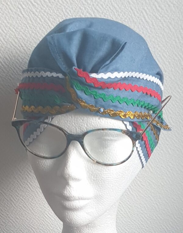 3.1Chapeau carabela en bleu clair cousu de zigzags quadricolors sur une tenue traditionnelle haïtienne. Taille uniforme. Entièrement conçu et réalisé aux ateliers AnjeroCréation à Paris. Prix :  29.95€.