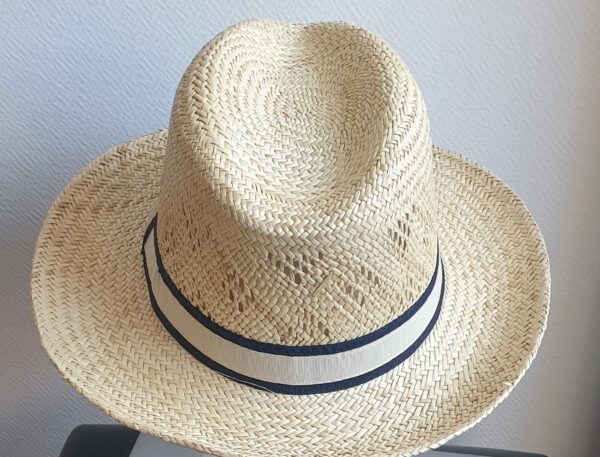 82Chapeau paille naturelle pour l'été, rafraichissant, confortable et léger à porter. Son style borsalino large bord légèrement relevé sur un montant remarqué et une entré de tête plus discrète, assorti d'un galon blanc aux bordures noires sont autant d'éléments lui confèrant un rendu singulier. Taille : 55, 57, 59, 59.
