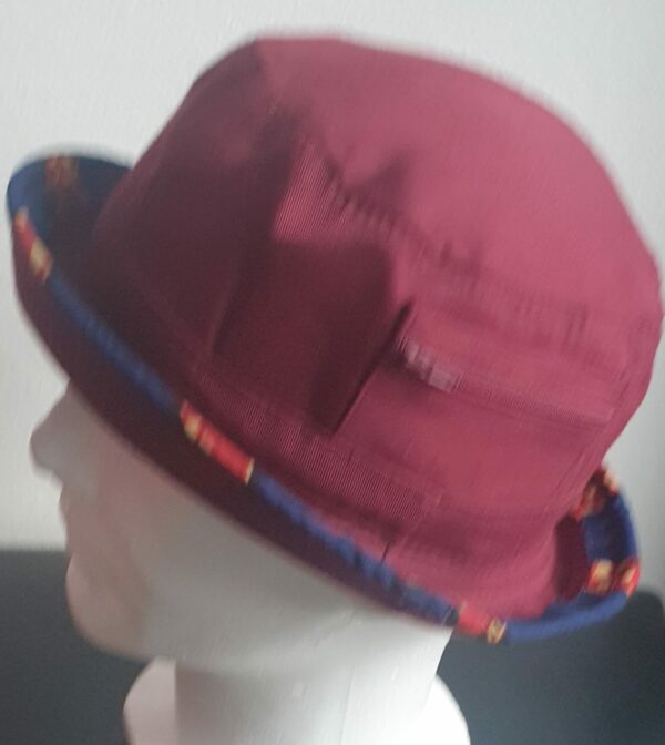 3.4Bob tout en rouge grenat sur un tissu 100% coton. L'ajout de deux poches latérales zipées apporte une touche harmonieuse à la confection. Les finitions en bordure sur le pourtour de ce couvre-chef sont en WAX et réalisées aux ateliers AnjeroCréation.